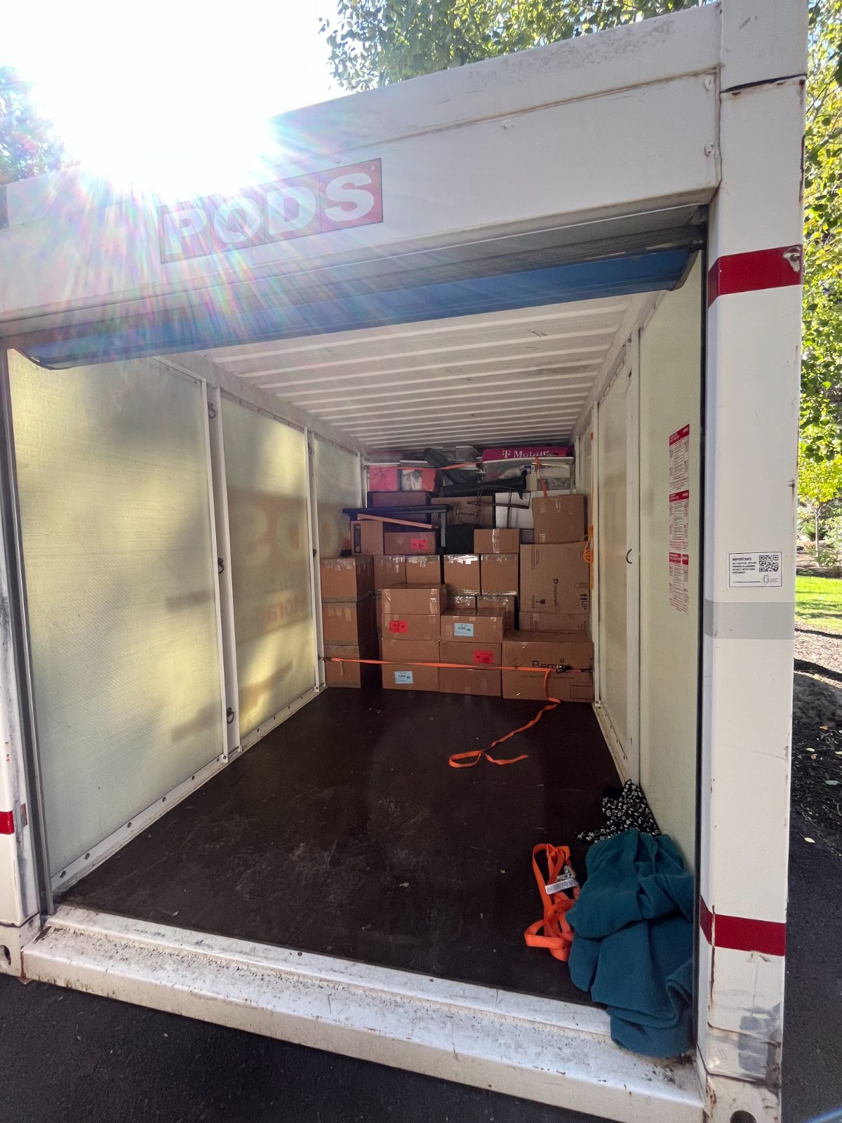 Storage container loaded with strapped-down boxes