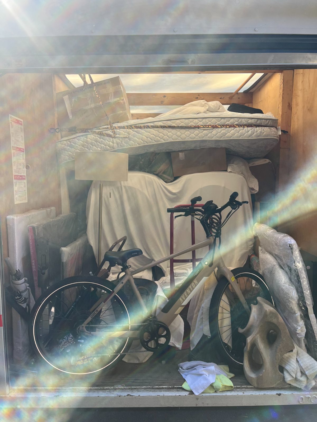 Storage container packed with furniture, a mattress, and a bike
