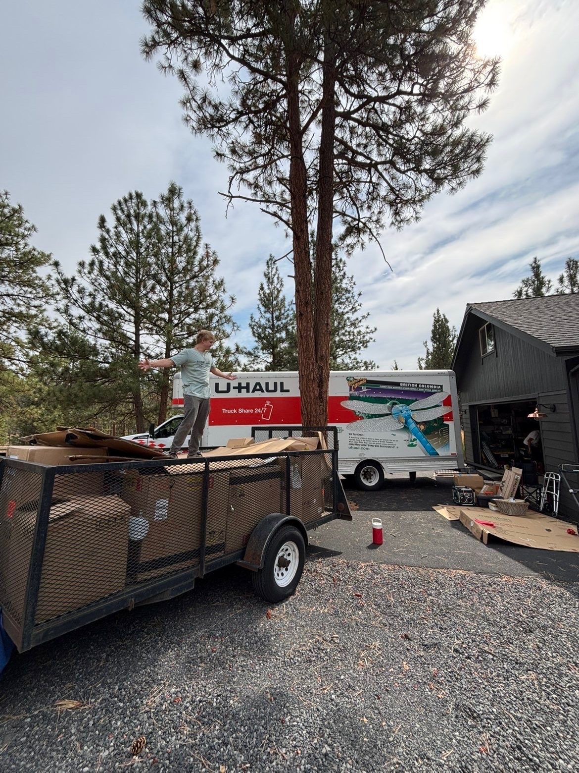 Trailer loaded with cardboard for hauling, next to a moving truck